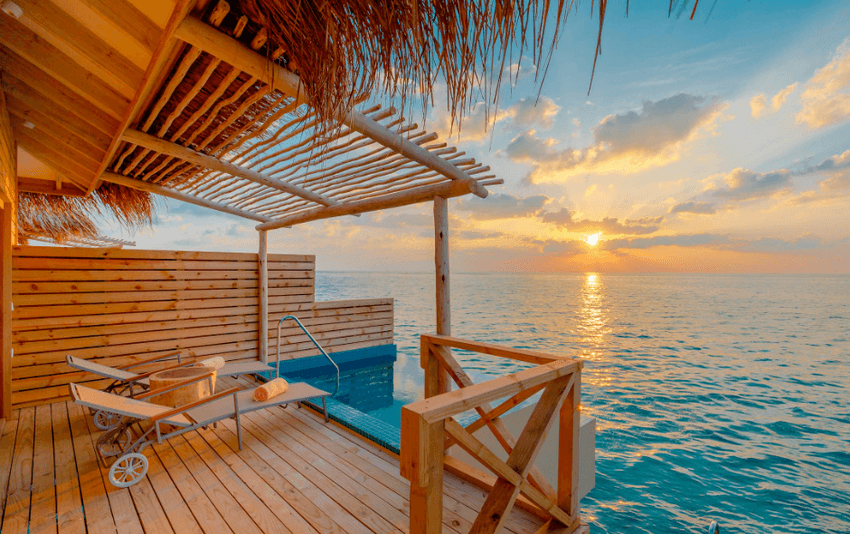 A couple relaxing by the pool at a luxury resort, a key consideration in the luxury resorts vs. budget stays debate.