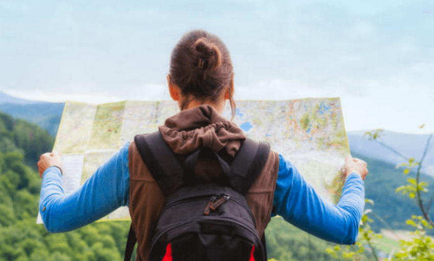 A cautious traveler checking their map, a proactive step to avoid the top travel scams to avoid while abroad.